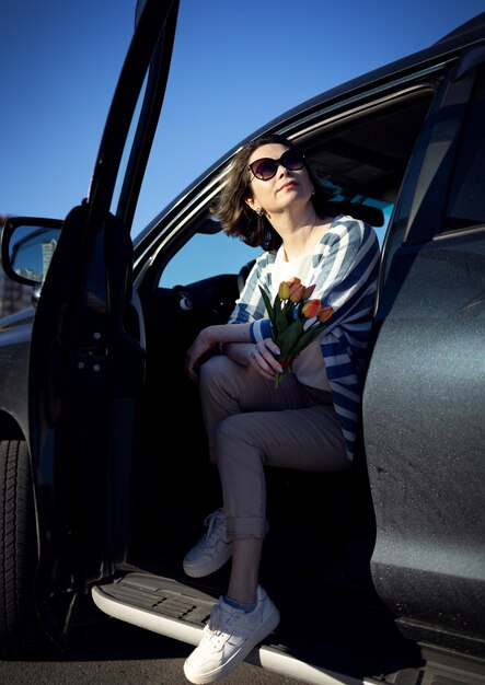 La fille est assise dans sa voiture