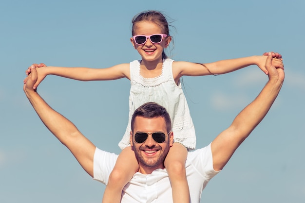 La fille est assise sur les épaules de son père