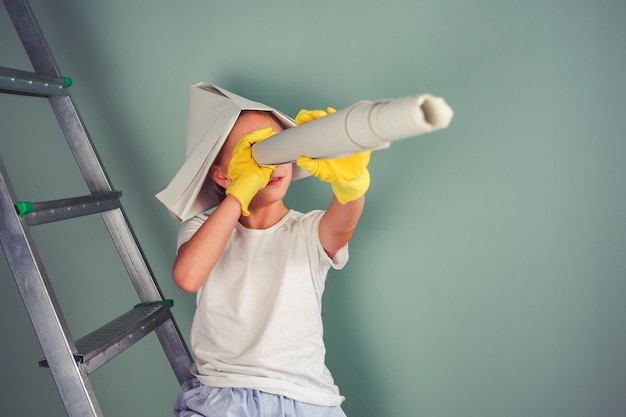 Une fille est assise sur un escabeau L'enfant a du papier peint dans ses mains Le concept de rénovation domiciliaire Place pour les textes Image teintée