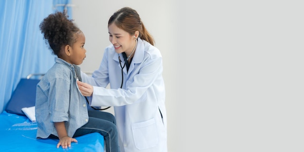 La fille est assise sur le lit du patient pour le médecin