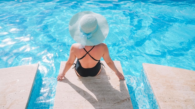 fille est assise à la piscine