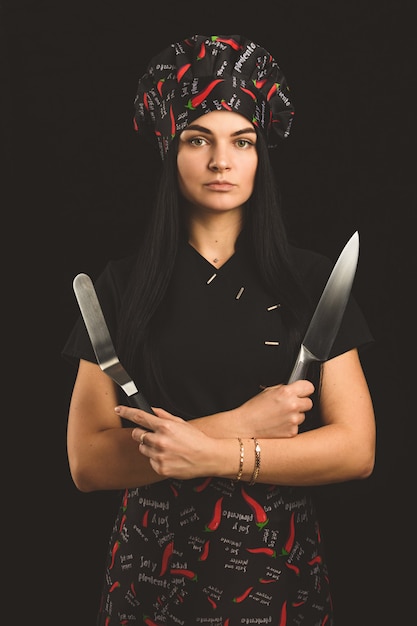 La fille est un chef professionnel avec un couteau et du piment.