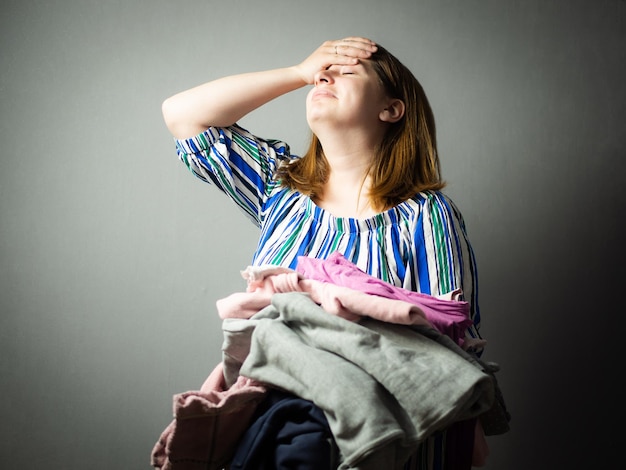 La fille est fatiguée des tâches ménagères la femme au foyer est stressée pendant le travail de repassage des vêtements