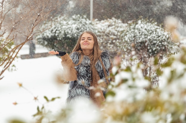 La fille est heureuse de la neige qui est tombée