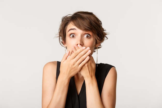 Fille étonnée haletante, couvrir la bouche avec les mains et à la surprise