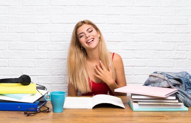 Fille étudiante adolescent à l'intérieur souriant beaucoup