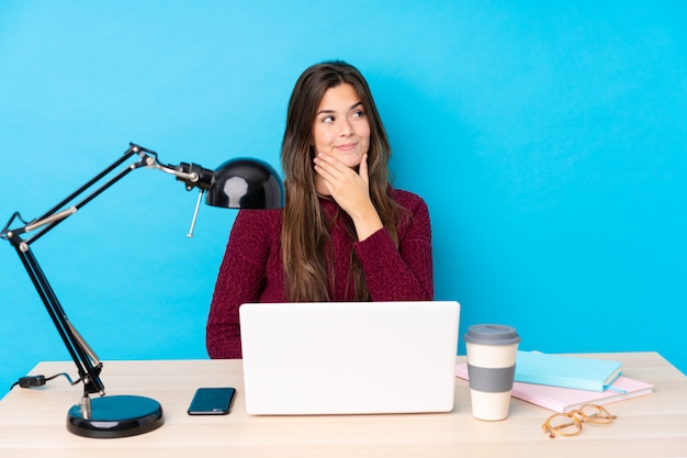 Fille étudiante adolescente dans un lieu de travail avec un ordinateur portable