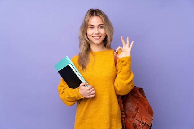 Fille étudiante adolescente isolée sur un mur violet dans une pose zen