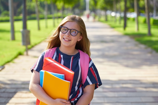 Fille étudiante blonde dans le parc avec des lunettes