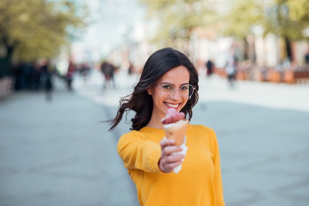 Fille étudiante avec cornet de crème glacée à l&#39;extérieur.