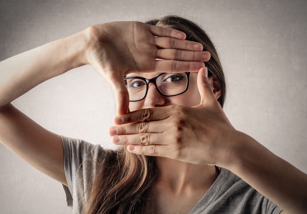 Fille étudiante créant un cadre avec ses mains