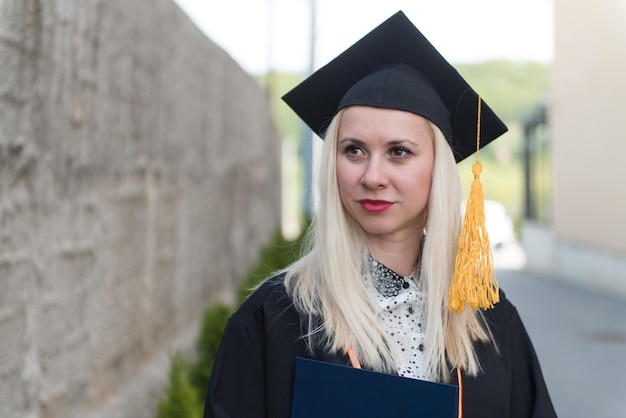 Fille étudiante diplômée dans une robe académique