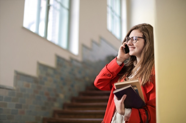 Fille étudiante parlant sur un smartphone