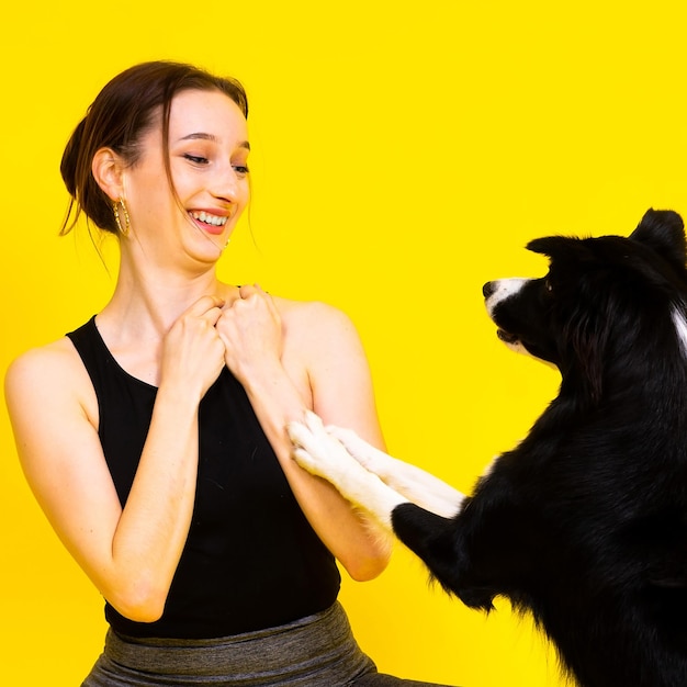 Fille excitée dansant avec une dame de portrait en studio border collie regardant un chien avec un sourire surpris