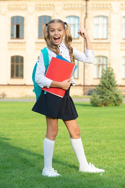 Fille excitée faisant un geste gagnant à l'école Heureuse adolescente en uniforme scolaire célébrant la victoire