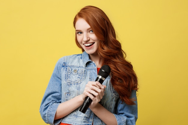 Fille Expressive Chantant Avec Un Microphone, Isolé Fond Jaune Vif.