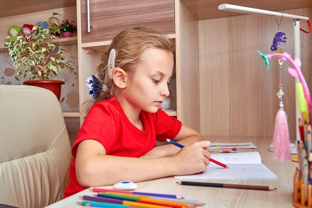 Fille à faire ses devoirs à la maison dans sa chambre