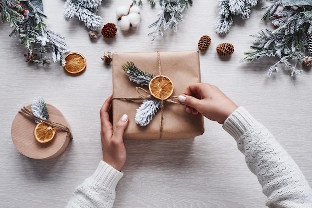 Fille faisant une boîte-cadeau. Vue de dessus du cadre festif de noël avec des décorations du nouvel an.