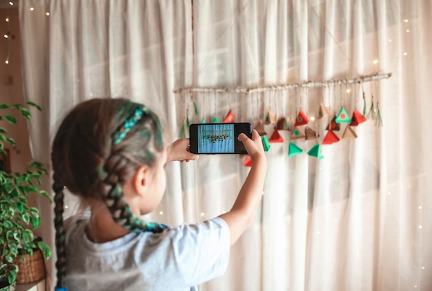 Fille faisant le calendrier de Noël de l'avent fait à la main avec des triangles de papier de couleur