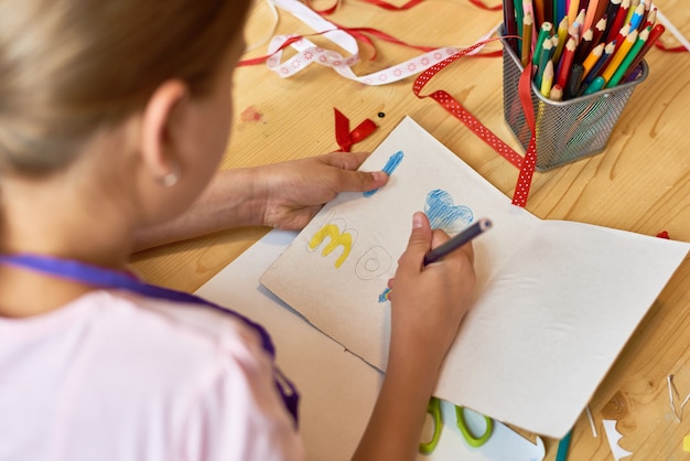 Fille faisant une carte à la main pour maman