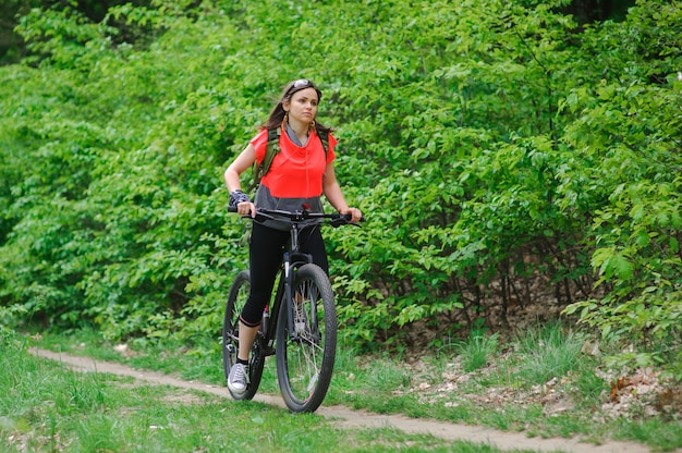 Fille faisant du vélo dans les bois