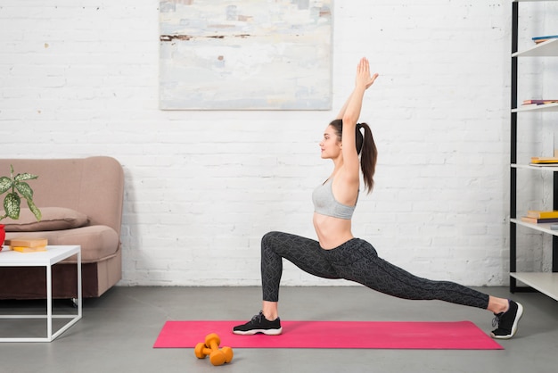 Fille faisant du yoga dans sa maison