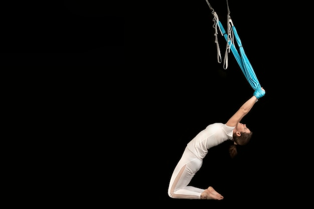 Fille faisant des étirements aérodynamiques Fille sportive pratiquant le yoga à la mouche dans un hamac