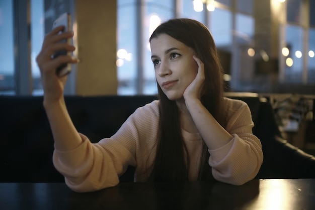 fille faisant selfie au café