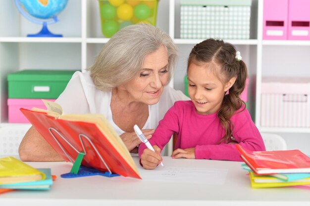 Fille faisant ses devoirs avec grand-mère au bureau