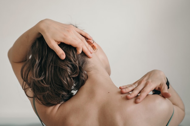 La fille fait l'automassage du cou en gros plan d'un massage relaxant des parties du corps d'une fille