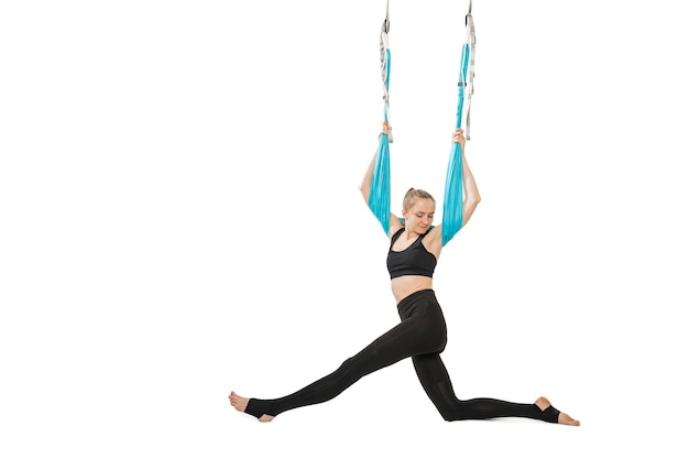 Fille fait de l'exercice de gymnastique aérienne sur un hamac de sport Exercice d'étirement Portrait en pied isolé sur fond blanc