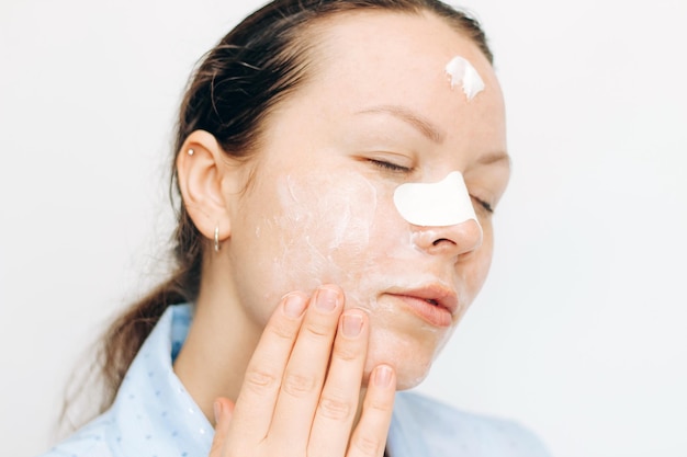 La fille fait un masque pour le nez contre les points noirs sur les problèmes de peau