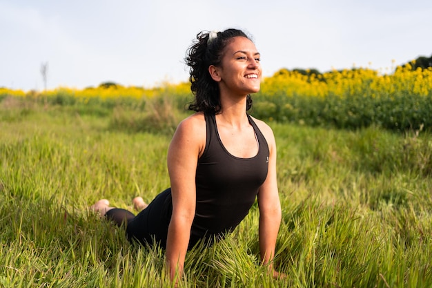 La fille fait une posture de yoga dans la nature