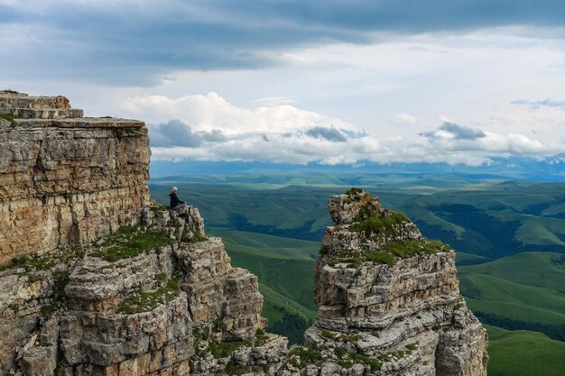 Une fille sur la falaise du plateau dans le contexte du mont Elbrouz Bermamyt