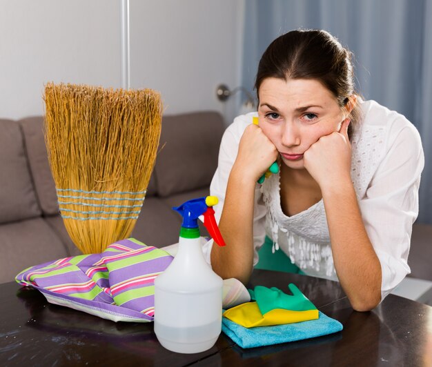 Fille fatiguée nettoie la maison