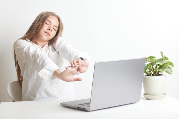 Fille fatiguée avec ordinateur portable sur fond blanc