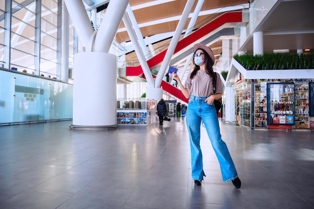 Fille à la fenêtre de l'aéroport attend un vol