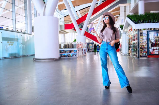 Fille à la fenêtre de l'aéroport attend un vol