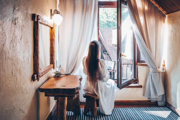 Fille à la fenêtre lisant un livre dans un vieux château