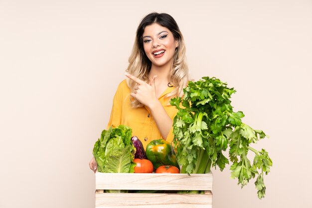 Fille de fermier adolescent avec des légumes fraîchement cueillis dans une boîte