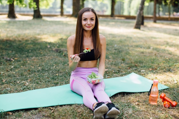 Fille de fitness mange sainement dans le parc