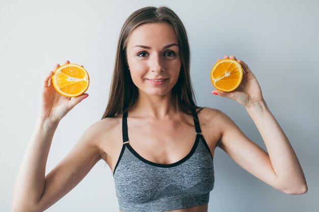 Fille de fitness montrant des fruits