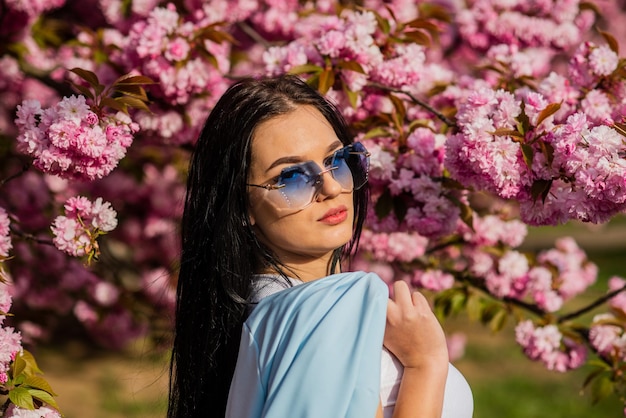 Fille en fleur de cerisier Femme lunettes de soleil fantaisie au printemps fleur fleurit Collection de mode printemps Arbre de Sakura en fleurs Passionné par le printemps Magasin de vêtements Superbe fille fantaisie à l'extérieur