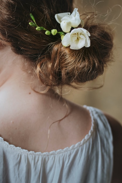 Fille avec des fleurs de freesia blanc dans ses cheveux