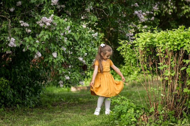 Photo fille et fleurs lilas dans le jardin en été