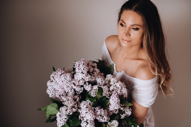 fille avec des fleurs lilas dans ses mains