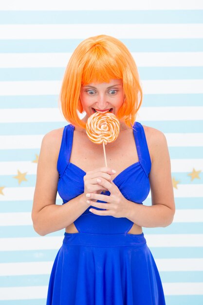 Fille folle d'humeur ludique Modèle de pin-up heureux avec une sucette à la main Fille de mode aux cheveux orange s'amusant Fille cool avec une sucette Femme sexy Tellement amusant Fêtarde folle Moment de plaisir