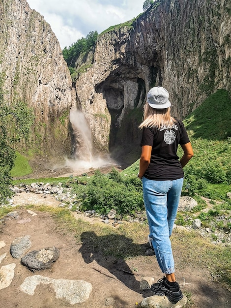 Une fille sur le fond de la cascade TuzlukShapa sur le territoire de KabardinoBalkaria Caucase Russie