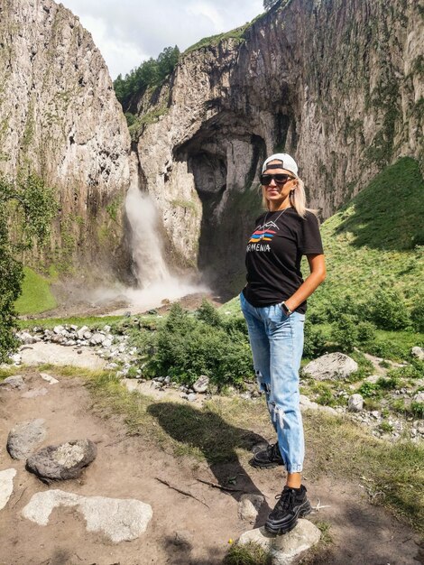 Une fille sur le fond de la cascade TuzlukShapa sur le territoire de KabardinoBalkaria Caucase Russie