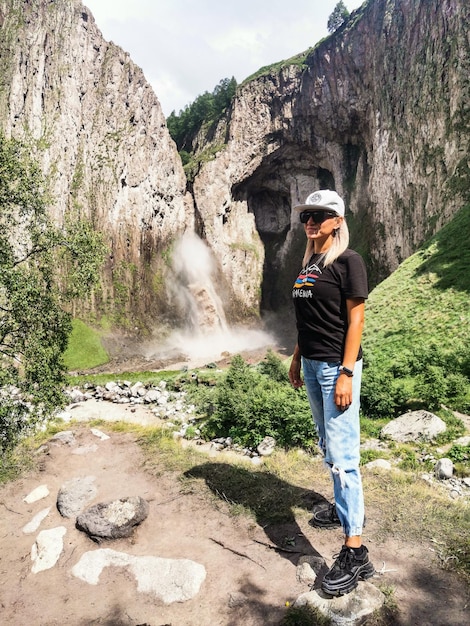 Une fille sur le fond de la cascade TuzlukShapa sur le territoire de KabardinoBalkaria Caucase Russie